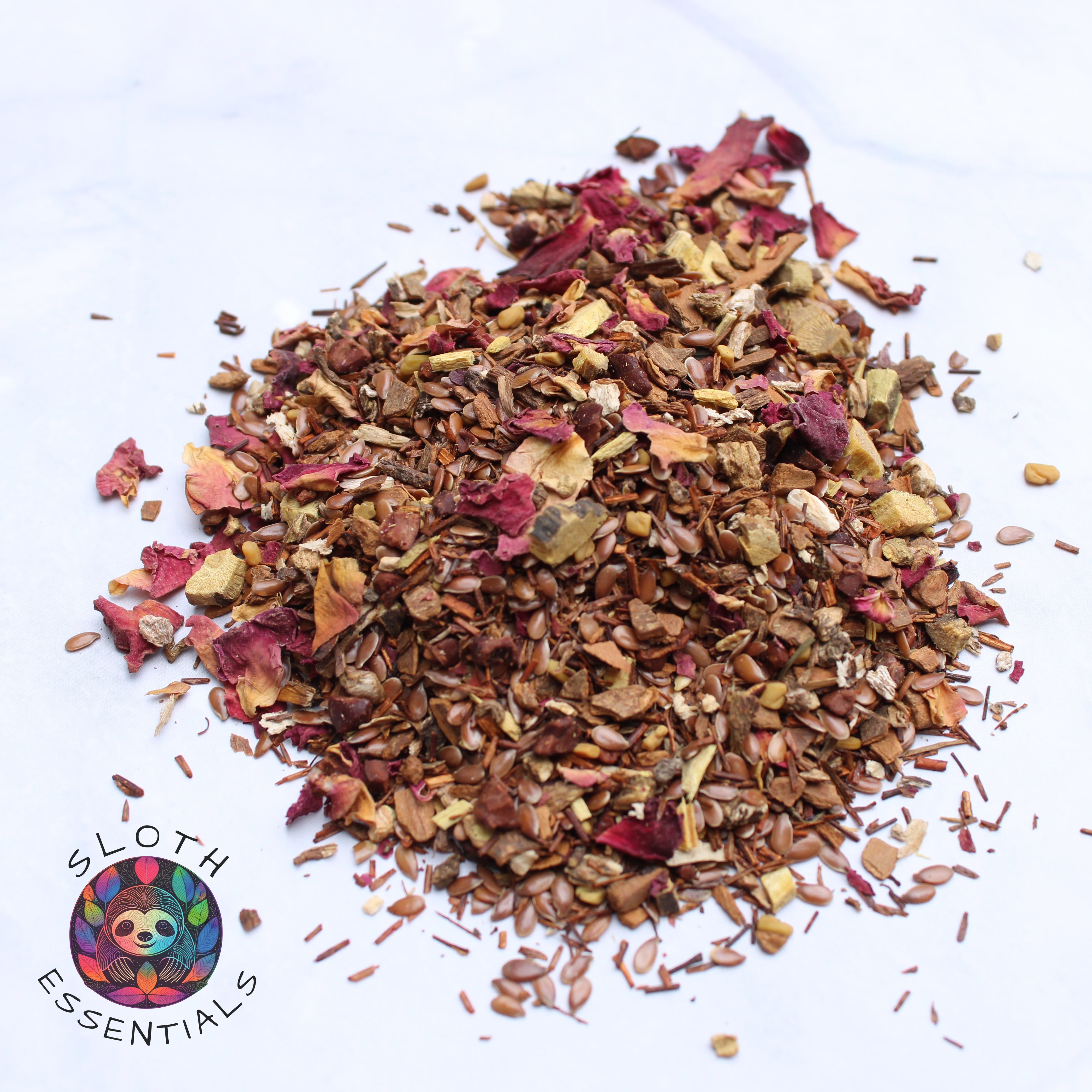 Zoomed-in photo of Colon Cleanse Tea showcasing vibrant colors and ingredients like flaxseed, rooibos leaf, cinnamon, dandelion root, licorice root, cacao nibs, fenugreek seed, and rose petals.